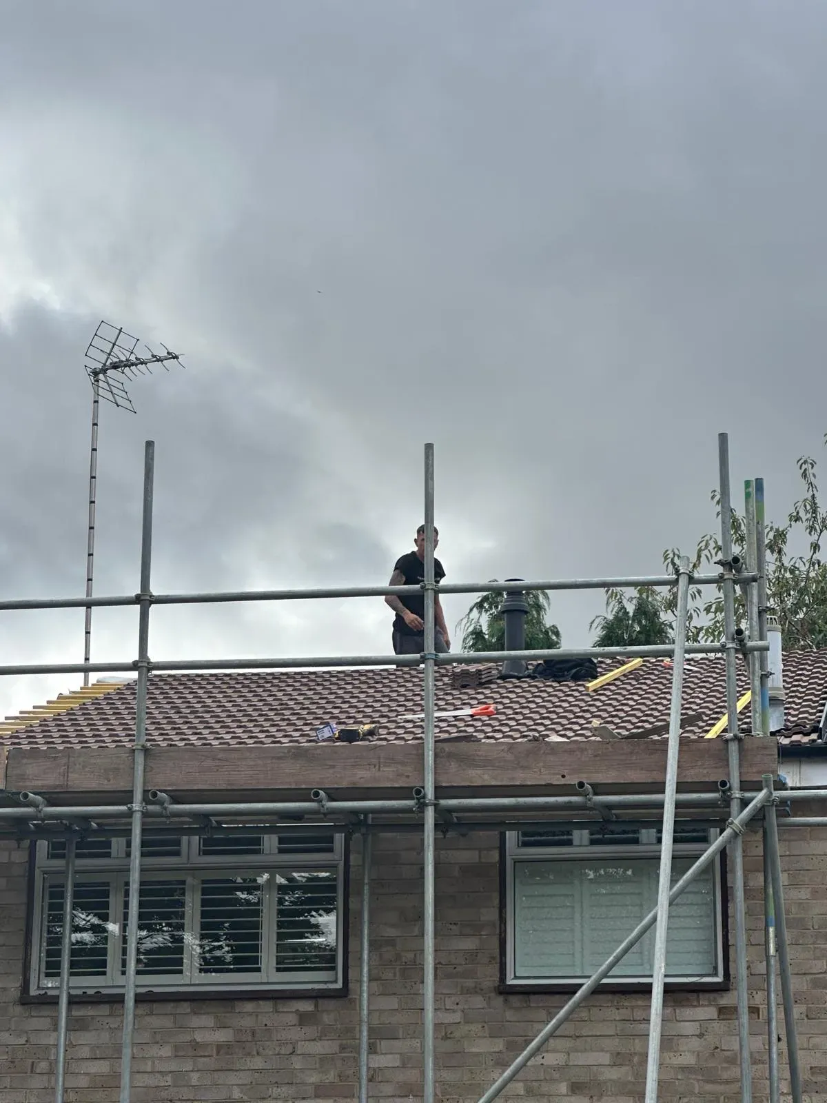 First Choice Roofing Kent roofer performing work on a tiled pitched roof with scaffolding in West Malling