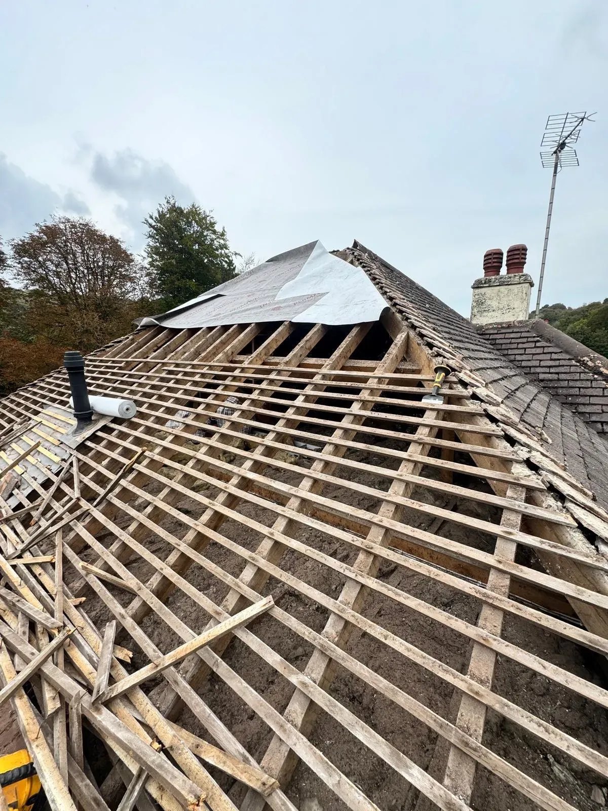 Professional roof replacement in progress in West Malling, showing exposed timber rafters and new roofing felt installation by First Choice Roofing Kent.