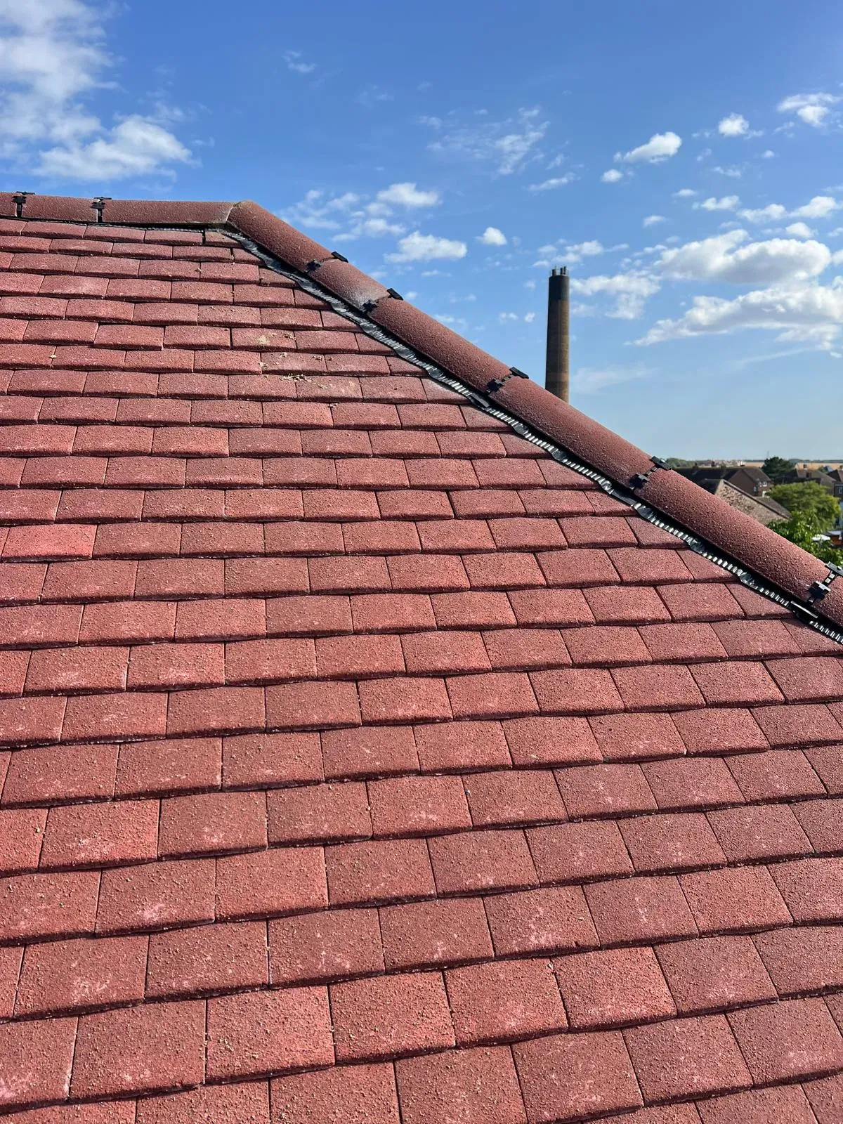 Professional red tiled roof with dry ridge system installation in West Malling Kent