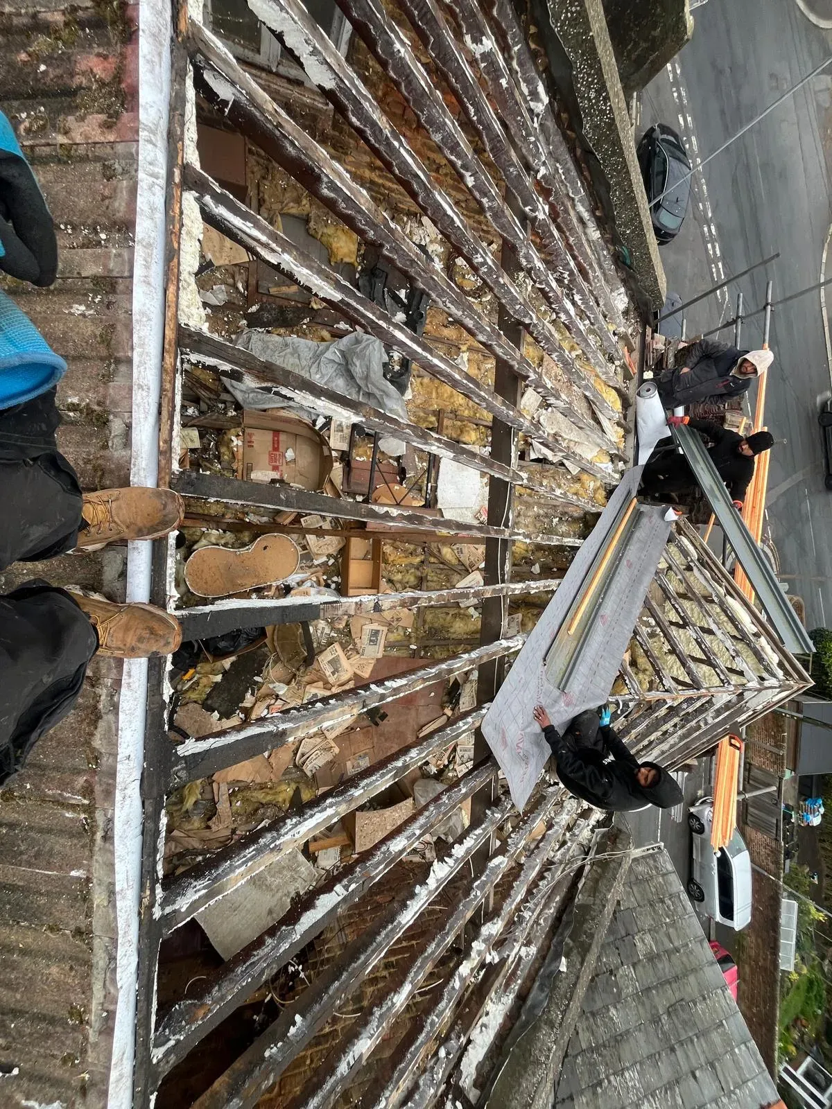 Roofers stripping back a roof and installing new membrane for a full roof replacement in West Malling, Kent.