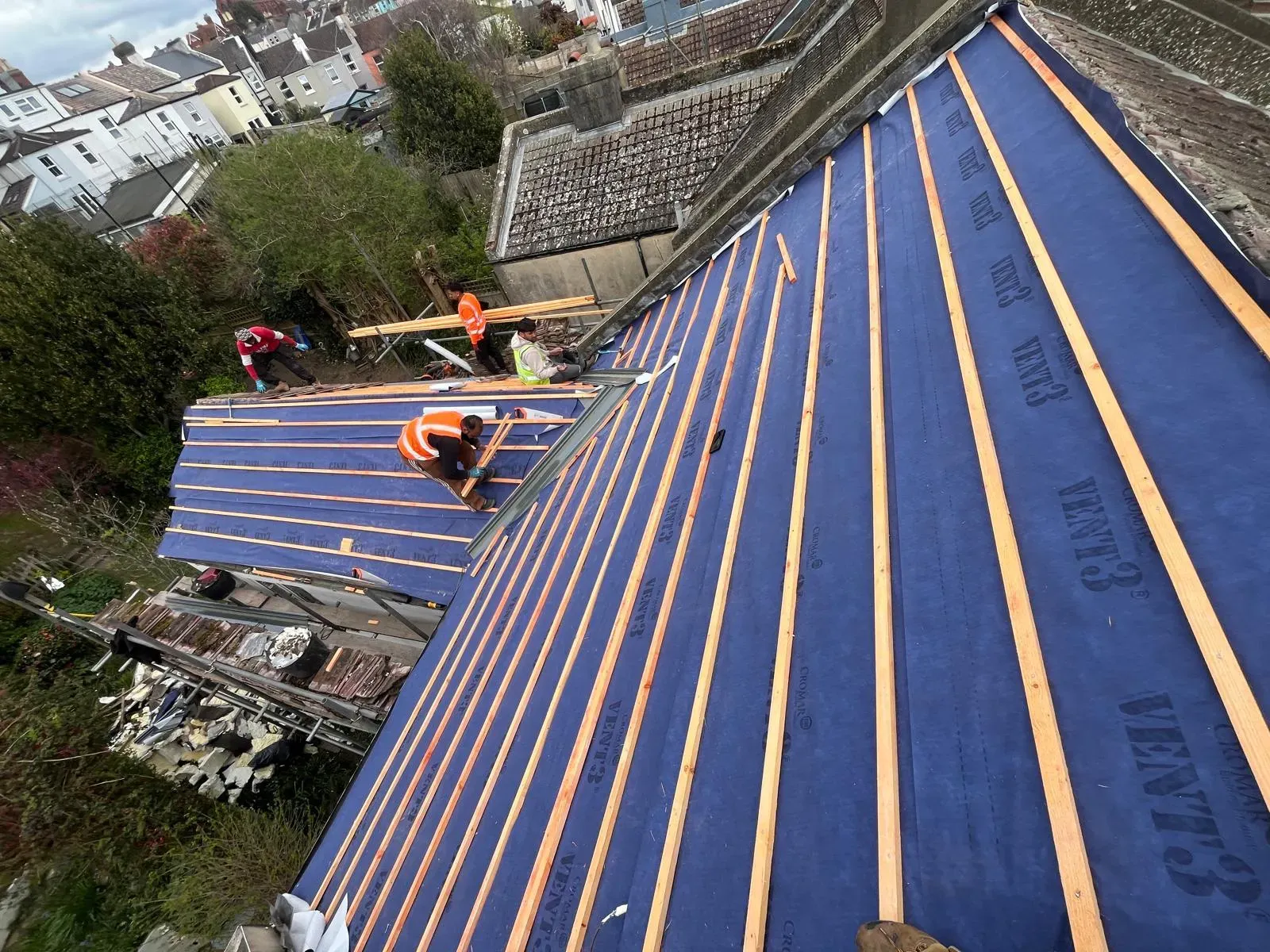 First Choice Roofing Kent team installing new blue roof felt and wooden battens on a pitched residential roof in West Malling.